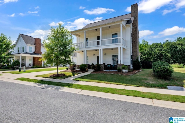 view of front of home with a front lawn and a balcony