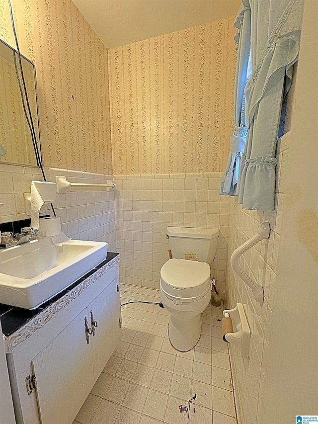 bathroom with vanity, tasteful backsplash, tile walls, toilet, and tile patterned floors