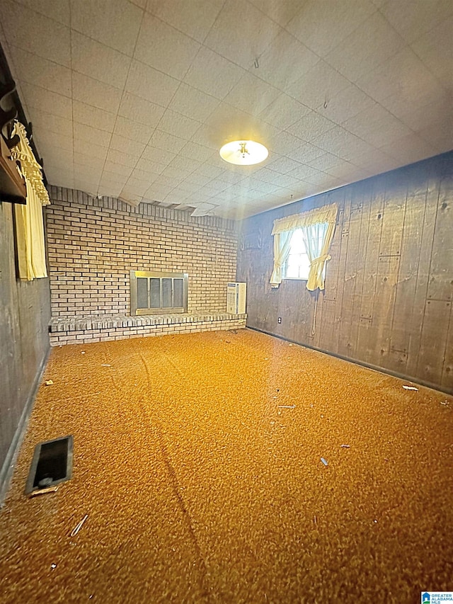 basement featuring a brick fireplace and wood walls