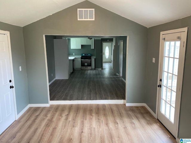 unfurnished living room with light wood-type flooring and vaulted ceiling