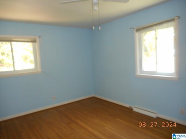 unfurnished room featuring a baseboard heating unit, ceiling fan, and hardwood / wood-style floors