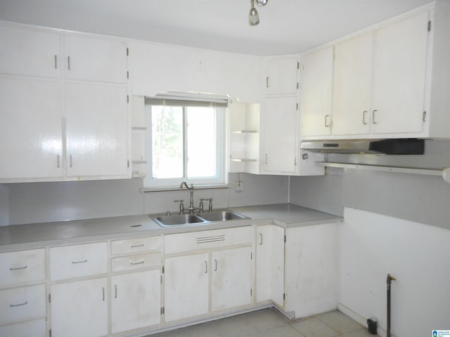 kitchen with light tile patterned floors, light countertops, a sink, and under cabinet range hood