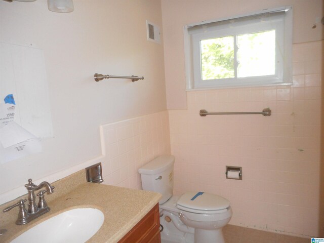 bathroom featuring vanity, tasteful backsplash, and tile walls