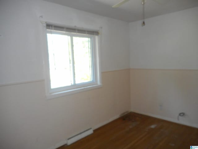 unfurnished room with a baseboard radiator, ceiling fan, and wood finished floors