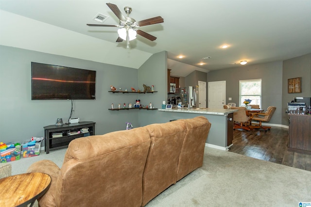 carpeted living room with lofted ceiling and ceiling fan