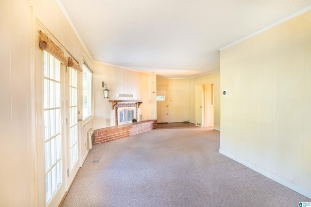 unfurnished living room featuring a fireplace, crown molding, and carpet