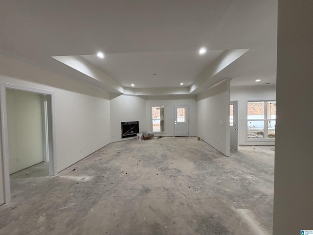 unfurnished living room featuring a wealth of natural light and a tray ceiling