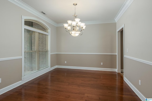 empty room featuring ornamental molding, baseboards, and wood finished floors