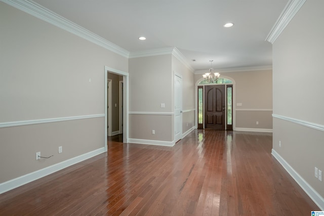 interior space with baseboards, crown molding, wood finished floors, and a notable chandelier