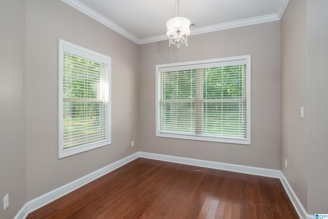 unfurnished room featuring dark wood-style floors, a chandelier, crown molding, and baseboards