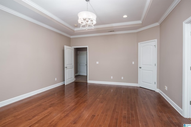 unfurnished room featuring an inviting chandelier, baseboards, hardwood / wood-style floors, and ornamental molding