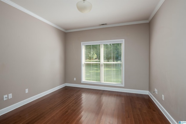 empty room featuring visible vents, baseboards, dark wood-type flooring, and ornamental molding