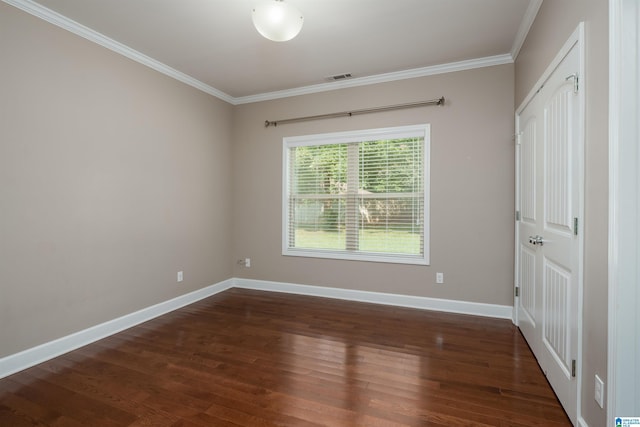 unfurnished bedroom with baseboards, wood finished floors, visible vents, and crown molding