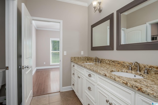 bathroom featuring tile patterned flooring, toilet, a sink, double vanity, and crown molding