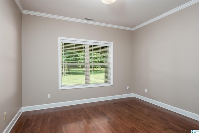 spare room with visible vents, crown molding, baseboards, and wood finished floors