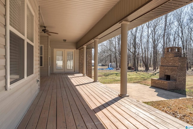 deck featuring ceiling fan, a patio, an outdoor brick fireplace, and french doors