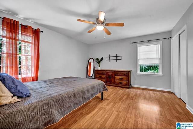 bedroom featuring light hardwood / wood-style flooring, ceiling fan, and a closet