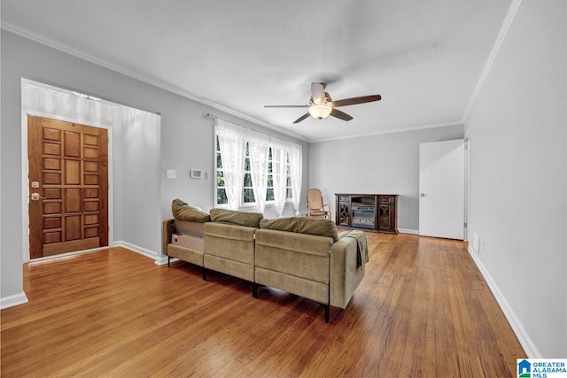 living room featuring ornamental molding, a fireplace, wood-type flooring, and ceiling fan