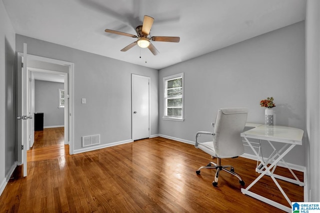 unfurnished office with hardwood / wood-style floors and ceiling fan