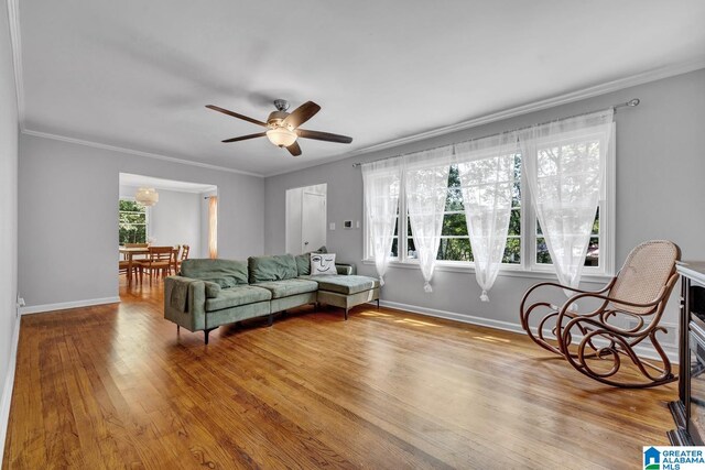 living room featuring crown molding, wood-type flooring, and ceiling fan