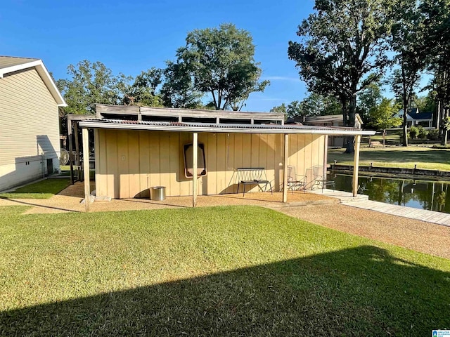 rear view of house featuring a water view and a lawn