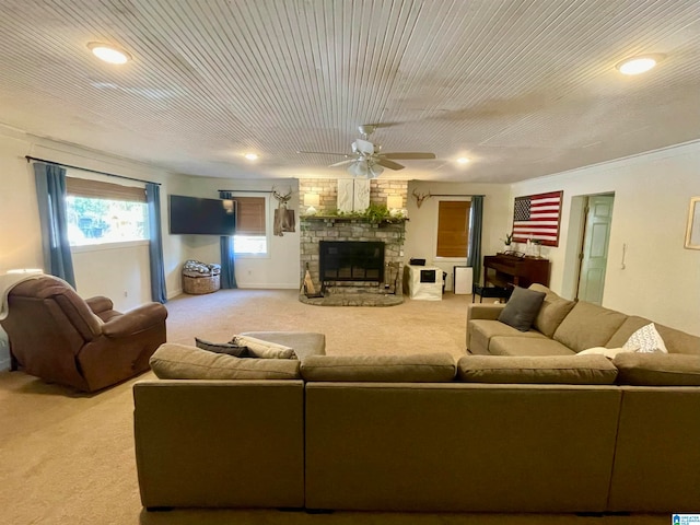 carpeted living room with a fireplace and ceiling fan