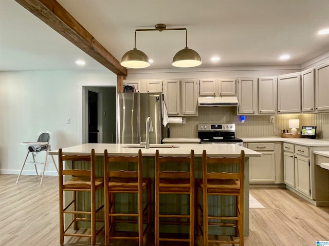 kitchen featuring stainless steel appliances, light hardwood / wood-style floors, sink, pendant lighting, and beam ceiling