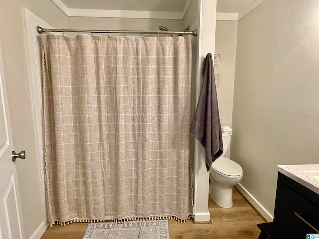 bathroom with a shower with shower curtain, crown molding, hardwood / wood-style floors, toilet, and vanity