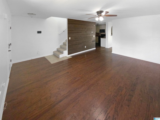 unfurnished room with dark wood-type flooring and ceiling fan