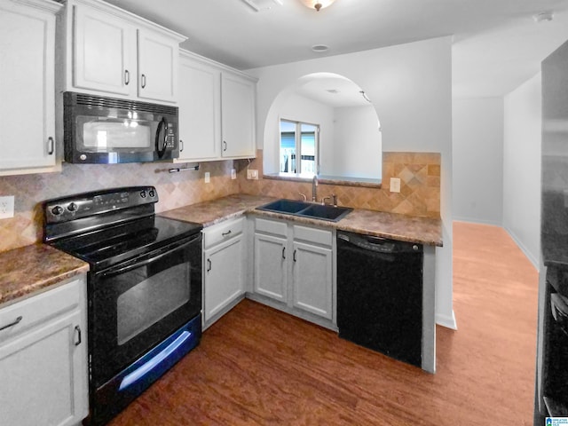 kitchen with black appliances, backsplash, and sink