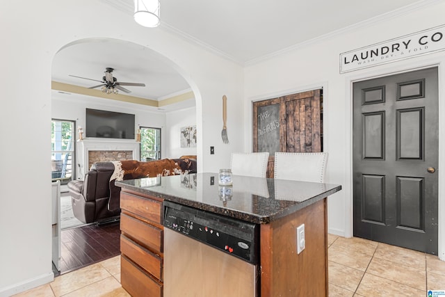 kitchen with dishwasher, crown molding, a kitchen island, and ceiling fan