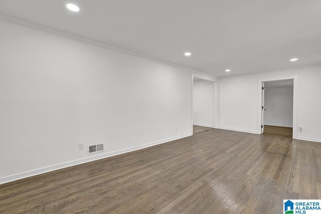 spare room featuring crown molding and dark wood-type flooring