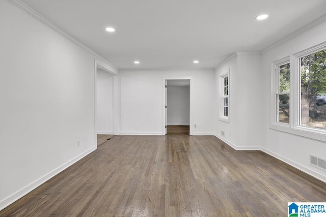 empty room featuring ornamental molding and dark wood-type flooring