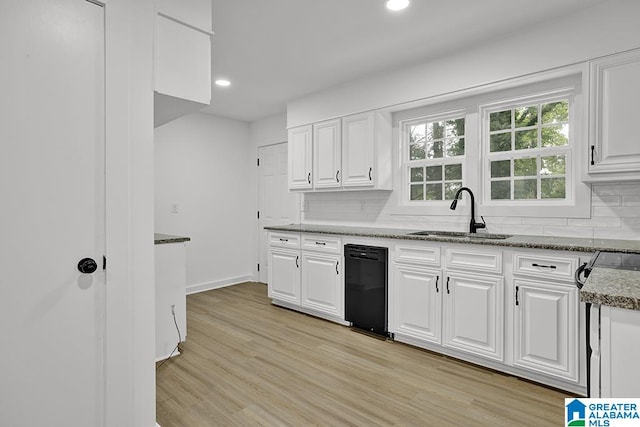 kitchen with white cabinets, light hardwood / wood-style flooring, light stone counters, sink, and tasteful backsplash