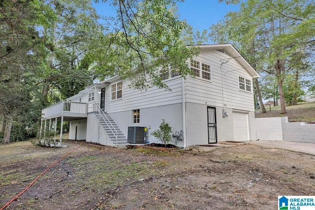 exterior space featuring a garage, a deck, and cooling unit