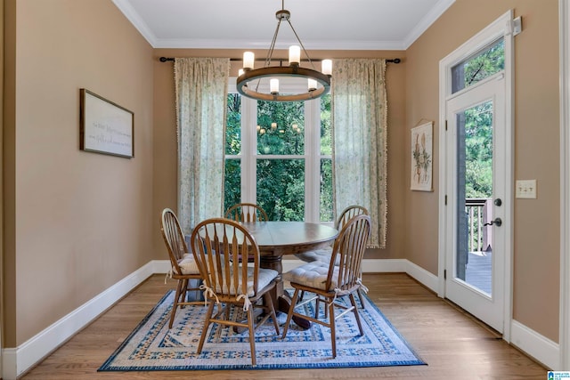 dining area featuring crown molding, light hardwood / wood-style flooring, and a chandelier