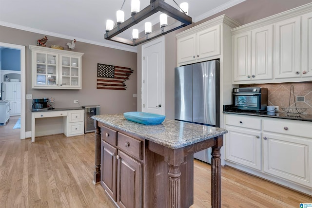 kitchen featuring a kitchen island, tasteful backsplash, hanging light fixtures, white cabinetry, and light wood-type flooring