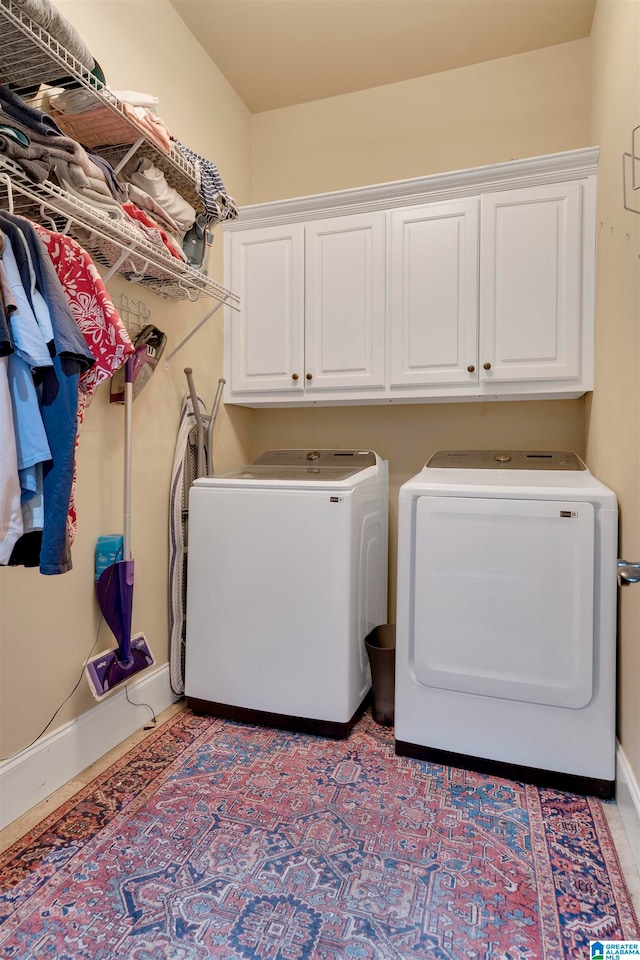 washroom featuring washing machine and dryer and cabinets