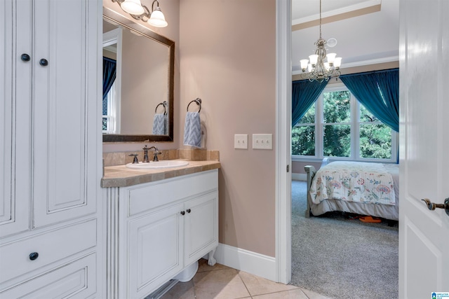 bathroom featuring crown molding, vanity, an inviting chandelier, and tile patterned floors