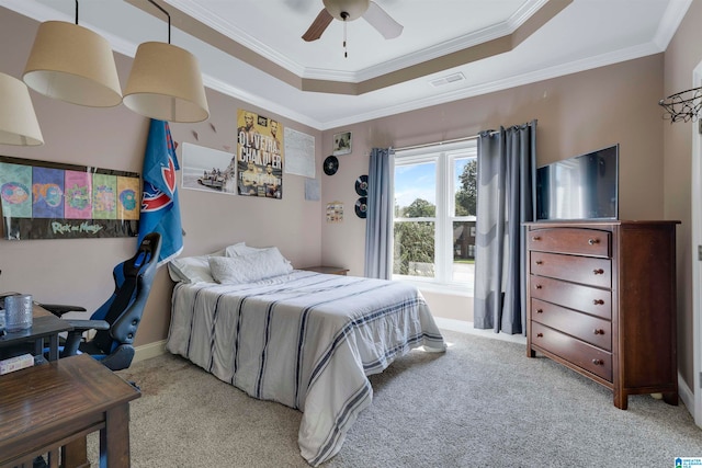 carpeted bedroom with ceiling fan, ornamental molding, and a tray ceiling