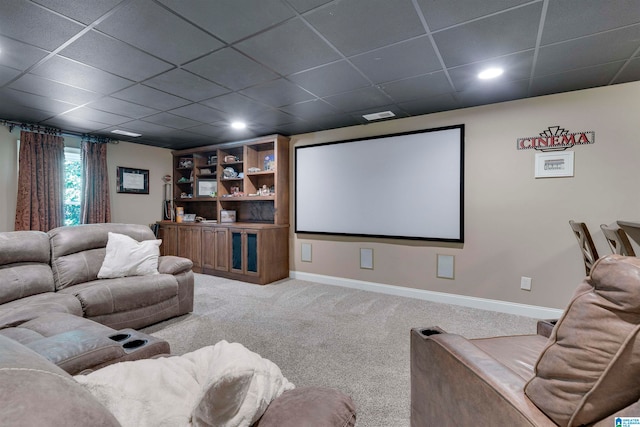 home theater room with a paneled ceiling and carpet