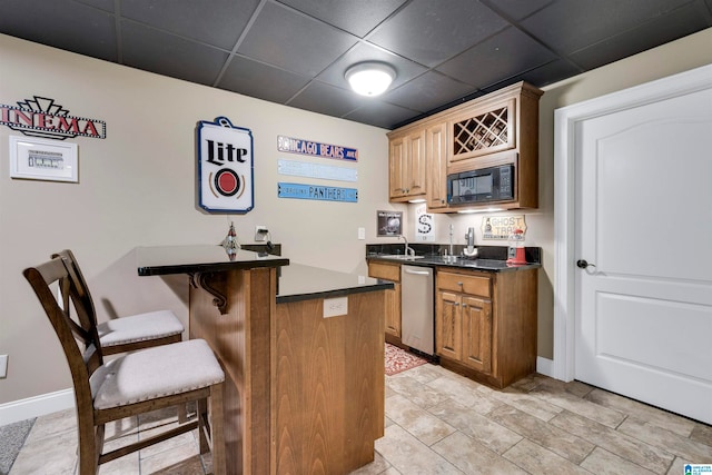 interior space with stainless steel dishwasher, sink, black microwave, and a drop ceiling