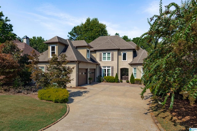 view of front of property with a garage and a front lawn