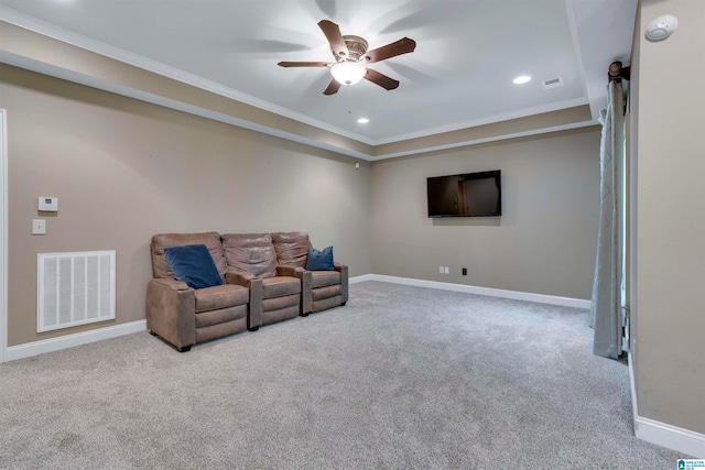 carpeted living room with crown molding and ceiling fan