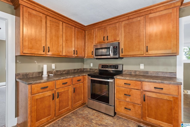 kitchen with a textured ceiling, stainless steel appliances, and tile patterned flooring