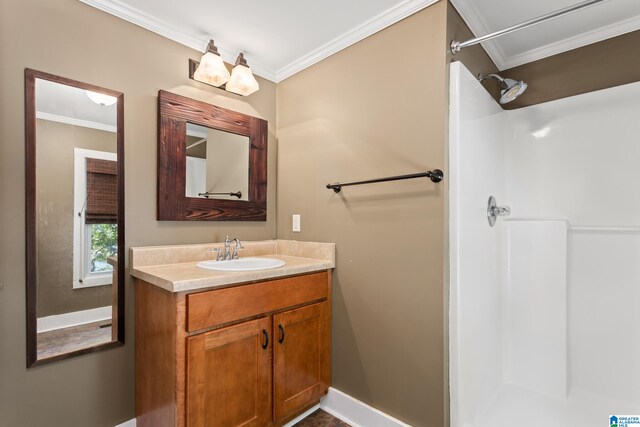 bathroom with ornamental molding, vanity, and a shower