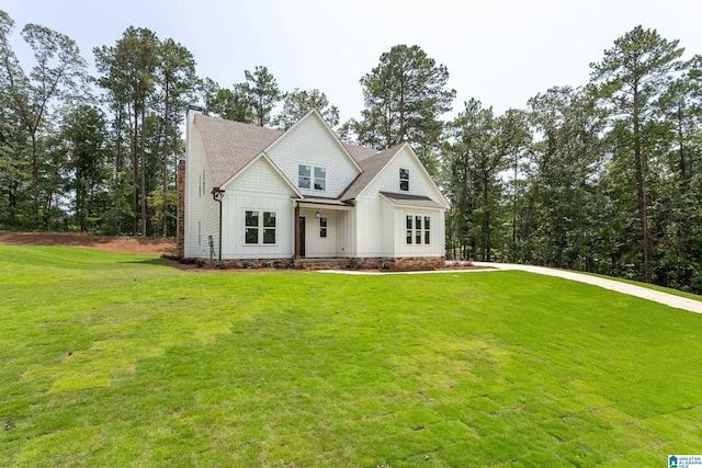 view of front of home featuring a chimney, a front lawn, and board and batten siding