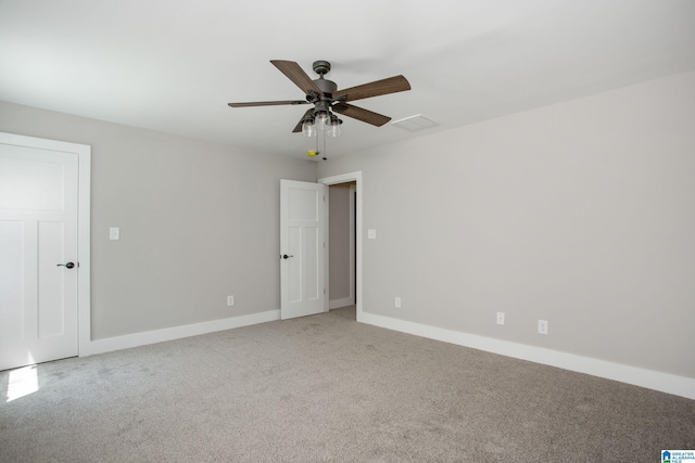 carpeted spare room with ceiling fan