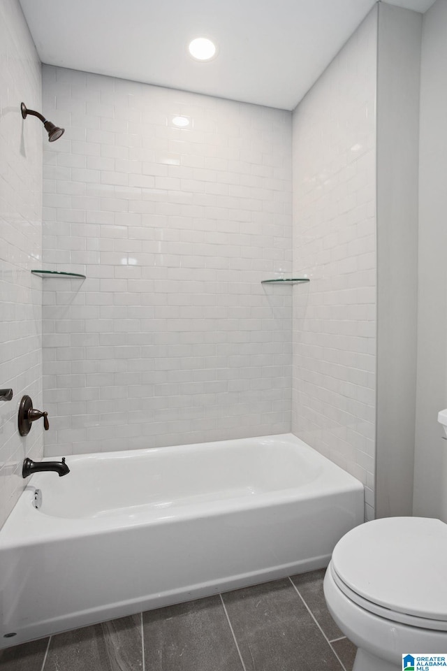 bathroom featuring toilet, tiled shower / bath combo, and tile patterned floors