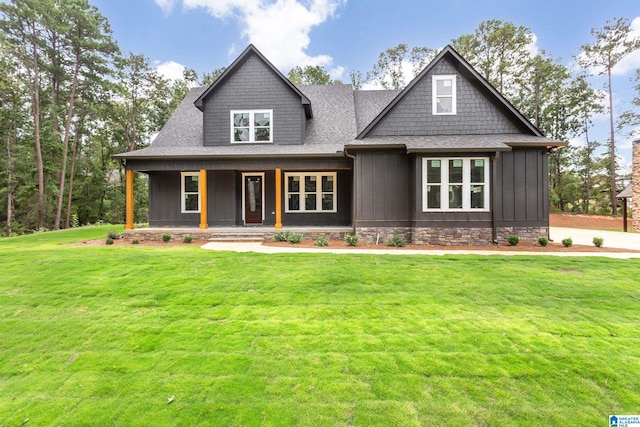 craftsman inspired home featuring covered porch, a shingled roof, board and batten siding, and a front yard